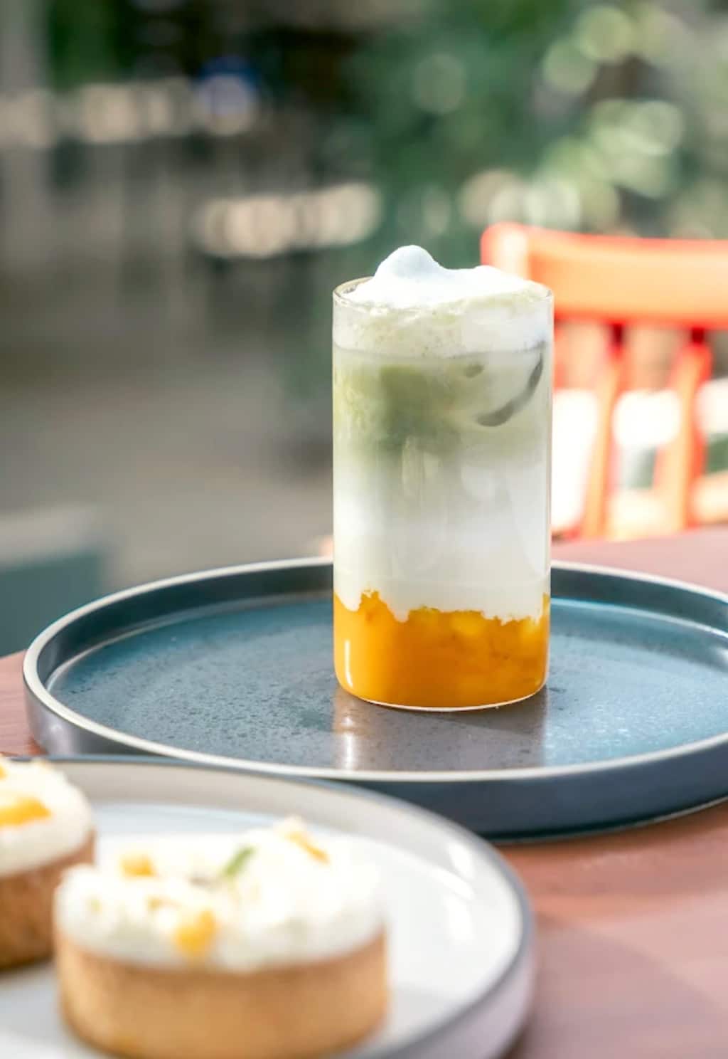 Layered iced matcha latte with dessert tarts at Bel Posto The Cafe